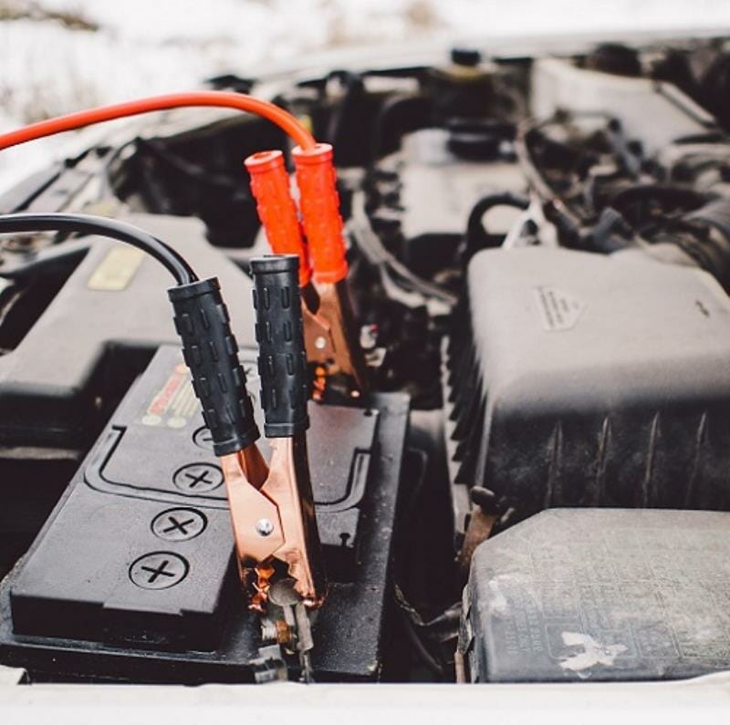 Jumper cables attached to the battery of a car
